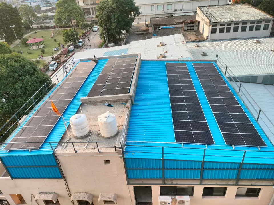 Commercial rooftop solar installation with rows of panels on a blue metal roof
